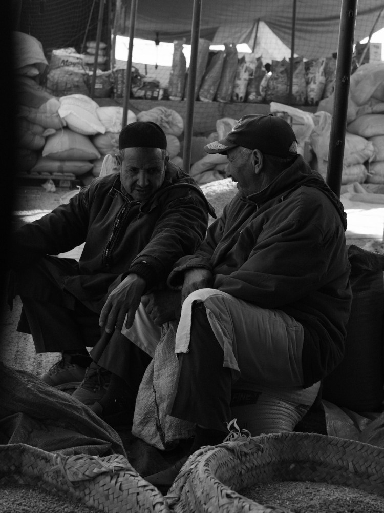 A friendly chat between two elderly men at the market