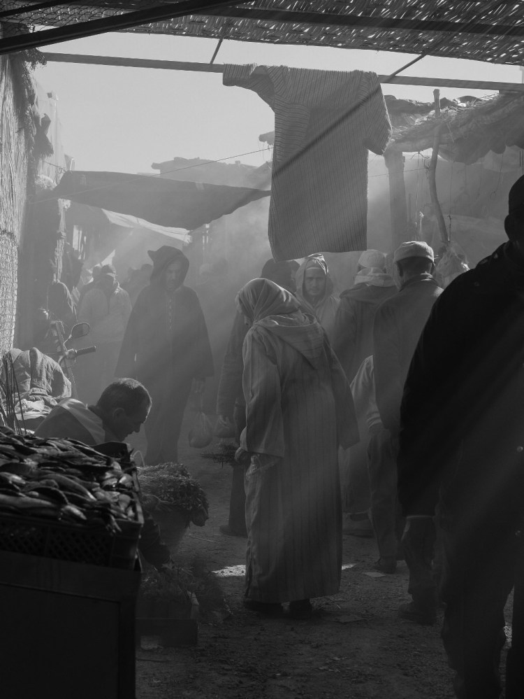 A woman walking through the alley of the market